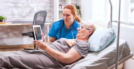caregiver and senior woman watching video